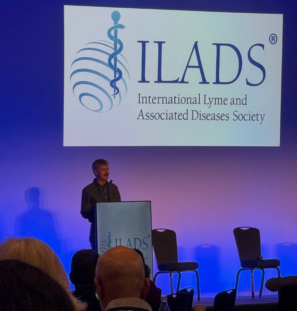 Tick Boot Camp at ILADS 2026: Official Podcast & Gala Emcees 12 Dr. Bill Rawls presenting on stage at the ILADS Scientific Conference.