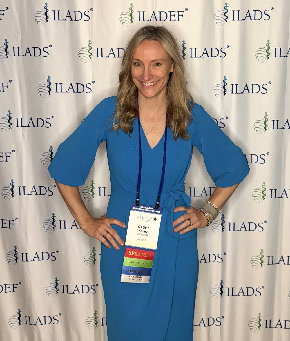 Tick Boot Camp at ILADS 2026: Official Podcast & Gala Emcees 11 Dr. Casey Kelley at the ILADS and ILADEF conference backdrop.