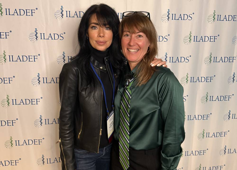 Tick Boot Camp at ILADS 2026: Official Podcast & Gala Emcees 7 Dr. Somer DelSignore and Executive Director Sarah Quillen at the ILADS backdrop.