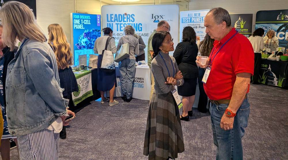 Tick Boot Camp at ILADS 2026: Official Podcast & Gala Emcees 16 Attendees talking with exhibitors at the 2026 ILADS conference.